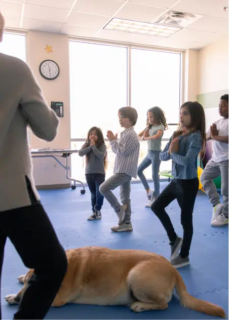 Kids doing exercises together while dog is sleeping