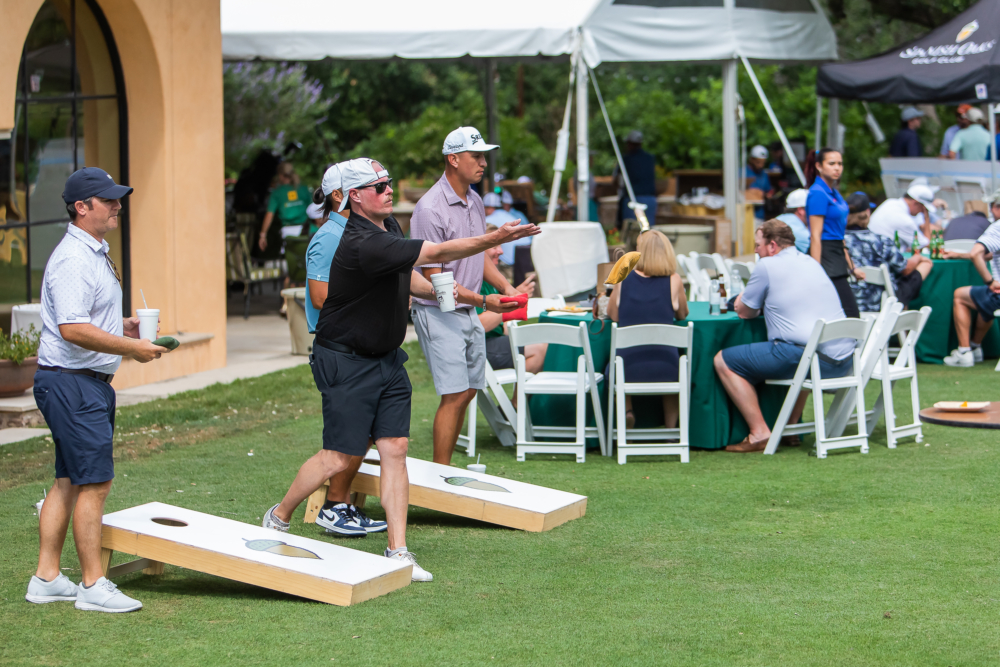 People Playing Cornhole Game at 2024 Protect Austin Kids Golf Classic Tournament