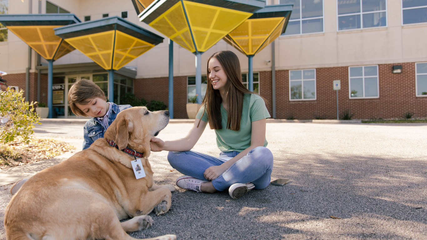 teen petting mickler the facility dog healing tails facility dog program center for child protection